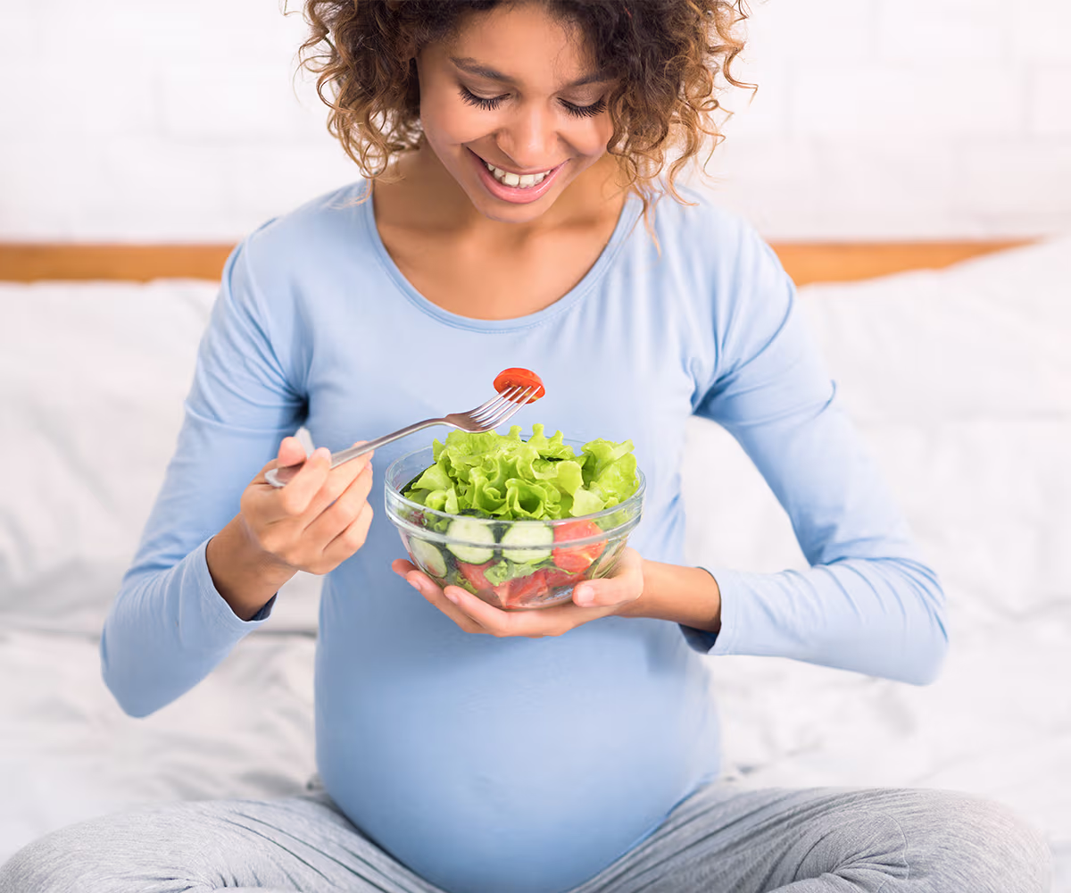 Nutrition During Pregnancy photo showing a pregnant woman eating a healthy salad
